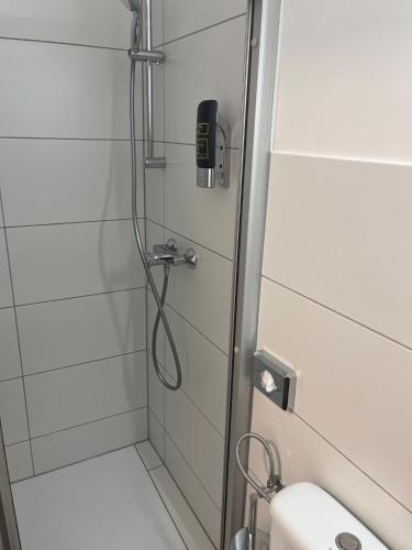 a bathroom with a shower with a phone in it at City Hotel Post 17 in Braunau am Inn