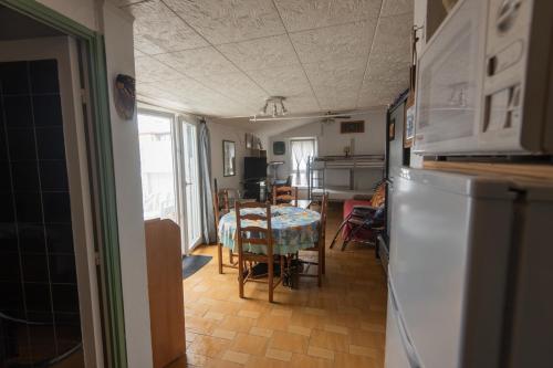 une cuisine et une salle à manger avec une table et un réfrigérateur dans l'établissement Appartement Confort 57 m2 avec terrasse parking couvert, au Cap d'Agde