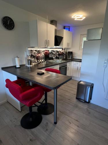 a kitchen with a table and two red chairs at Urlaub in Andreasberg 2 in Sankt Andreasberg