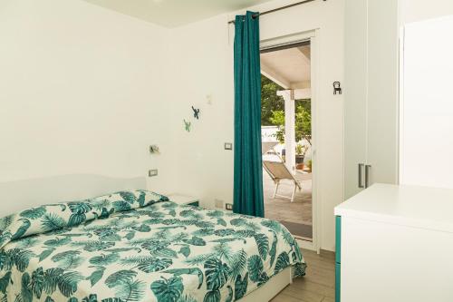 a bedroom with a bed and a sliding glass door at Palinuro Casa Vacanza Melita in Palinuro