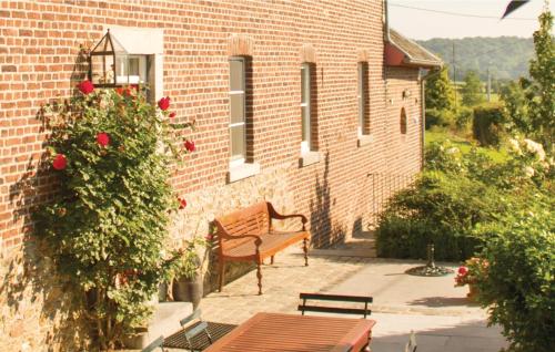 a bench in front of a brick building with roses at Seven-Bedroom Holiday Home In Remersdaal in Remersdaal