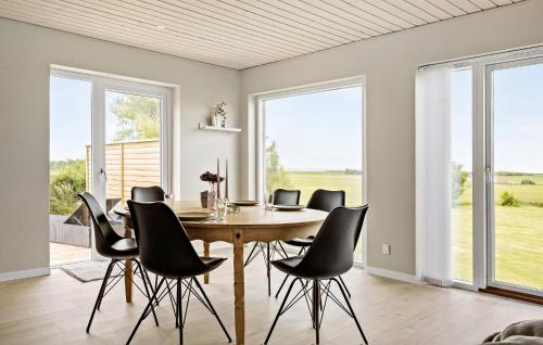 a dining room with a wooden table and black chairs at Nice Home In Thyholm With Wifi in Thyholm