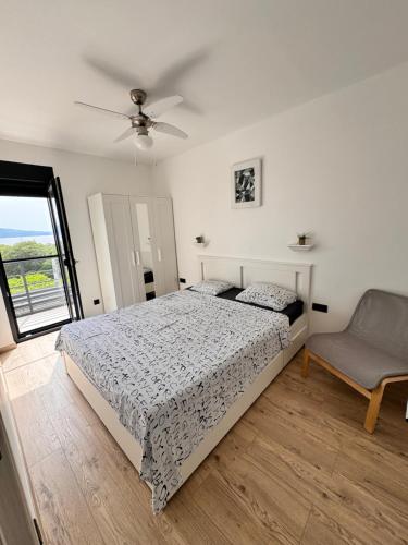 ein Schlafzimmer mit einem Bett, einem Ventilator und einem Stuhl in der Unterkunft Apartment Noa in Novi Vinodolski