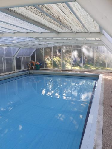 a large swimming pool with a ceiling and windows at Cabana da Oliveira in Marco de Canaveses