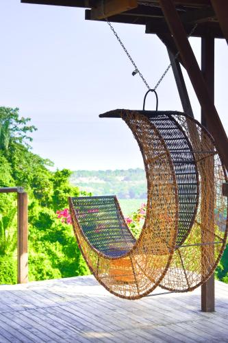 a rattan hammock hanging from a roof at Paraiso Ahimsa in Buritaca