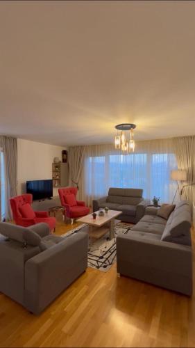 a living room with couches and red chairs at شقة نهر اليجا in Sarajevo