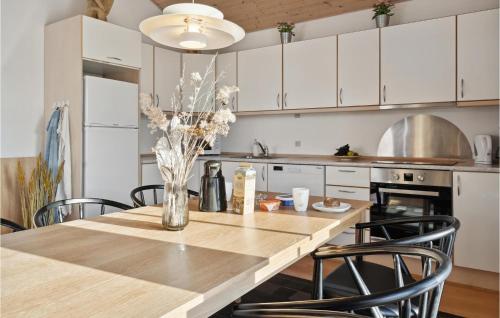 a kitchen with a table with chairs and a vase with flowers at Pet Friendly Home In Gråsten With Wifi in Gråsten
