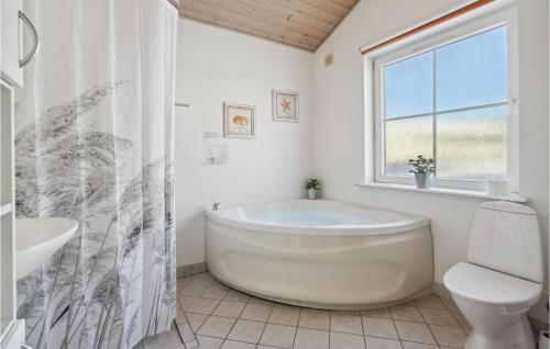 a bathroom with a tub and a toilet and a window at Pet Friendly Home In Gråsten With Wifi in Gråsten