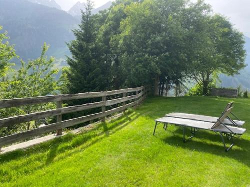 a bench sitting in the grass next to a fence at Nebenhaus Sagritzerwirt in Großkirchheim
