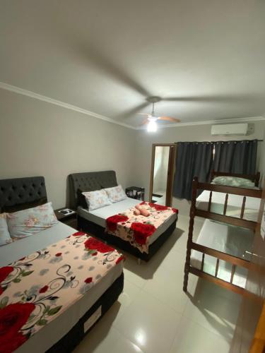 a living room with two beds and a chair at Pousada do Maninho in Penha