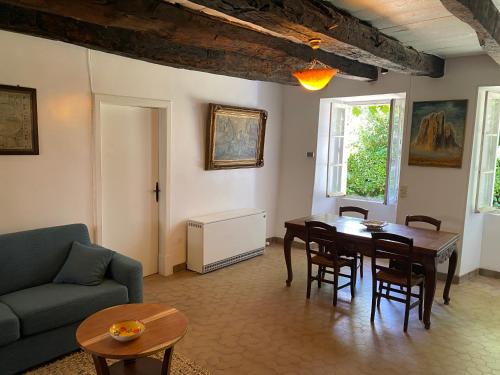 un salon avec une table et un canapé bleu dans l'établissement Chez Malou, à Pinsac