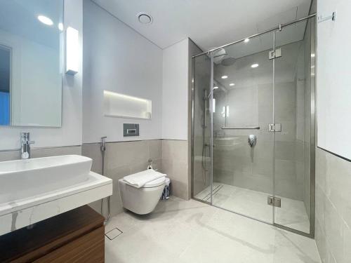 a bathroom with a shower and a toilet and a sink at Luxe & Comfy Madinat Jumeirah - Apartment with Scenic Views - Pool Managed by SunnyHomes in Dubai