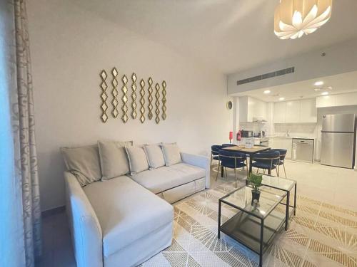 a living room with a white couch and a table at Luxe & Comfy Madinat Jumeirah - Apartment with Scenic Views - Pool Managed by SunnyHomes in Dubai
