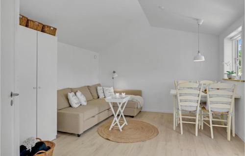 a living room with a couch and a table and chairs at 2 Bedroom Beautiful Home In Jægerspris in Jægerspris