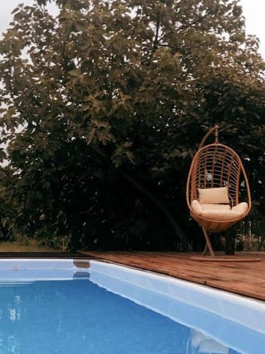 a rattan chair sitting on a deck next to a pool at Souto Guimarães Country House in Guimarães