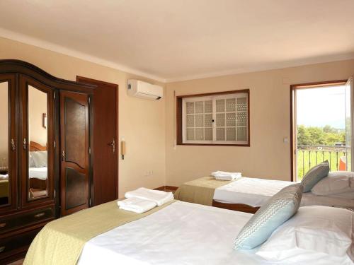 a hotel room with two beds and a window at Souto Guimarães Country House in Guimarães