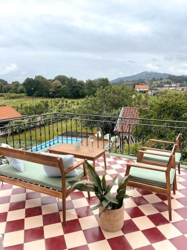 a patio with two chairs and a table and a pool at Souto Guimarães Country House in Guimarães