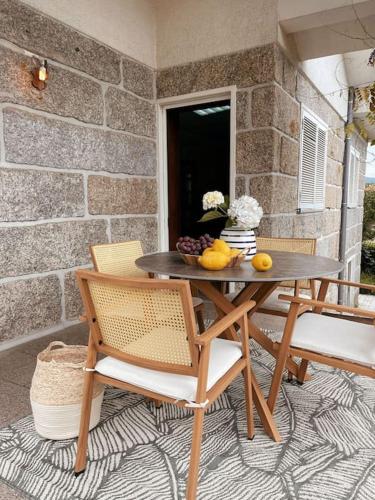 a table with a bowl of fruit on a patio at Souto Guimarães Country House in Guimarães
