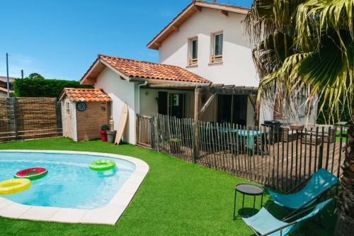 une cour arrière avec une piscine avec deux frisbees dans l'établissement VILLA CASA KOKO 10 PERS piscine chauffée, pétanque, ping pong VIEUX-BOUCAU, à Vieux-Boucau-les-Bains