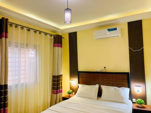 a bedroom with a bed and a window at Residence OKEO in Yaoundé