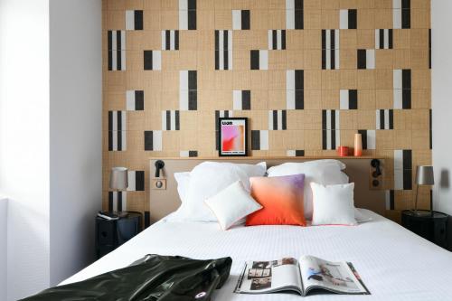 a bedroom with a bed with a large headboard at Hôtel Argia in Hasparren