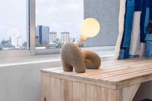 a stuffed teddy bear sitting on a table with a light at Sixteen By Sixteen in Lagos