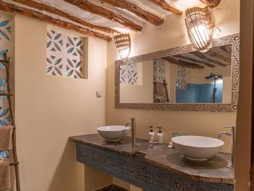 a bathroom with two sinks and a mirror at Marafiki Bungalows in Kiwengwa