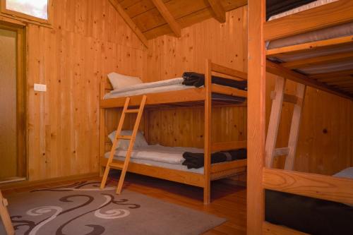 a room with two bunk beds in a wooden cabin at Rafting Camp Tara Center Tri Vodenice in Bastasi