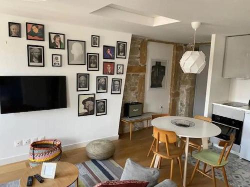 - un salon avec une table, des chaises et une télévision dans l'établissement Superbe T2, Vue fourvière, à Lyon
