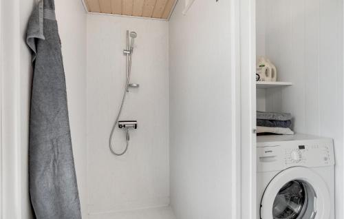 a bathroom with a shower and a washing machine at Holiday Home Svenstibakkevej Denmark in Lild Strand