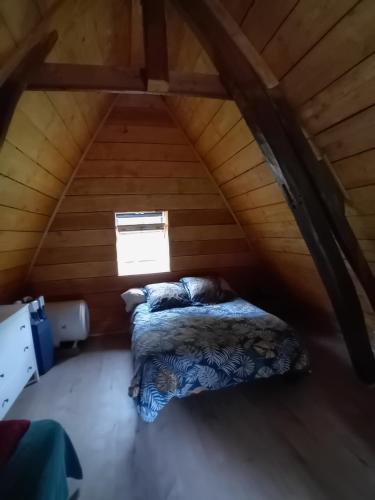een slaapkamer met een bed op zolder bij Paisible Cahute in La Poterie-Mathieu