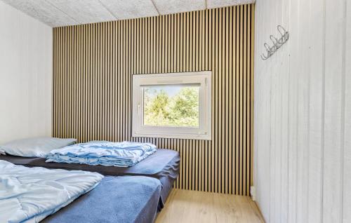 two beds in a room with a window at Cozy Home In Hirtshals With Kitchen in Hirtshals