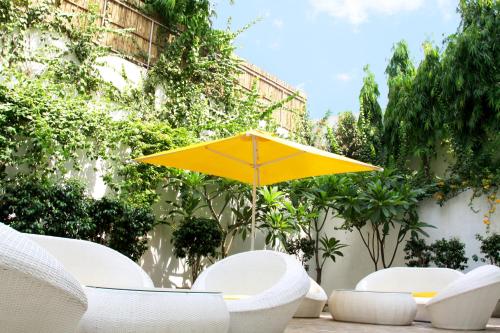 a yellow umbrella sitting on a patio with chairs at Bloomrooms @ Link Road in New Delhi