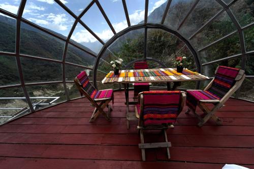 a table and chairs on a deck in a dome house at CUSCO Hotel Capsula in Santa Teresa