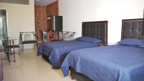 a bedroom with two beds and a table and chairs at Hotel Dubai de Miramar in San Blas