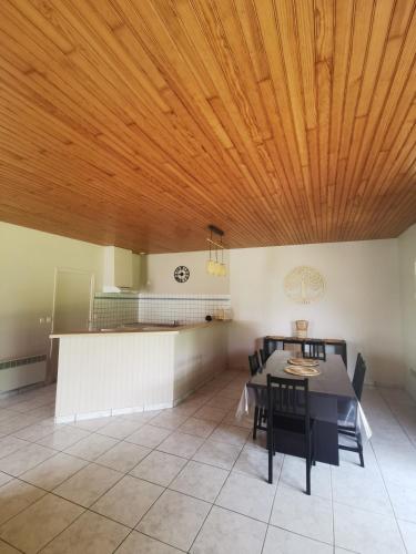 d'une salle à manger avec une table et un plafond en bois. dans l'établissement Maison entre Terre et Mer, à Saint-Jean-de-Marsacq