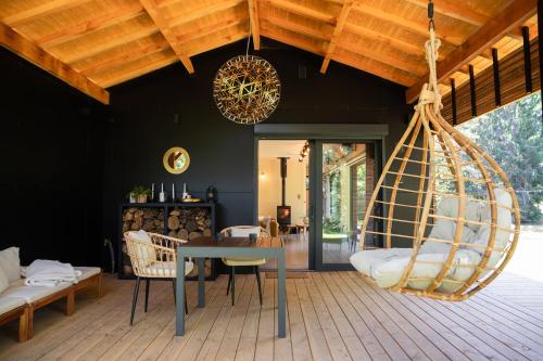 une chambre avec une table et une balançoire dans l'établissement Lodge 5 étoiles - Home Chic dans les prés, à Angoisse