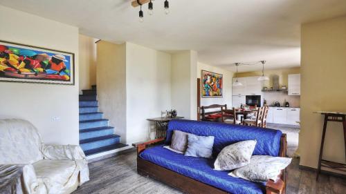 a living room with a blue couch and a kitchen at Casa Tamara in Coreglia Antelminelli