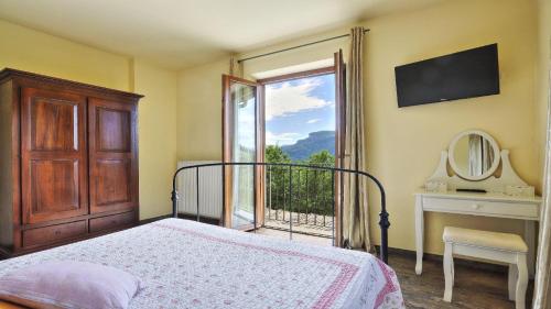 a bedroom with a bed and a window with a view at Casa Tamara in Coreglia Antelminelli