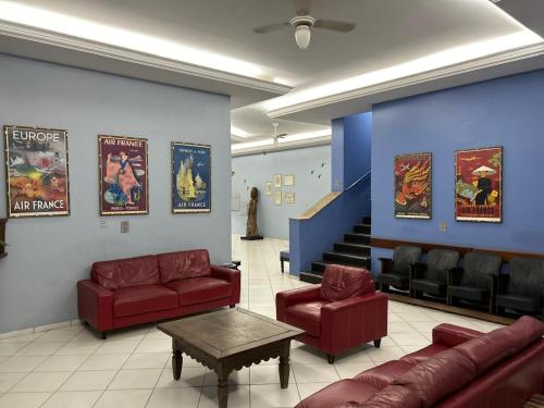 a waiting room with red couches and a staircase at Hotel Goiânia Palace in Goiânia