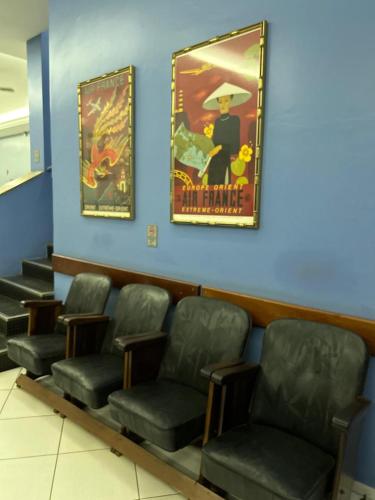 a waiting room with chairs and a poster on the wall at Hotel Goiânia Palace in Goiânia