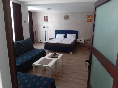 a hotel room with a bed and a couch and a table at Къща Принцеса Анастасия in Chiprovtsi
