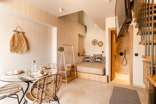 a room with a table and chairs and a bed at ADORNO PRIVATE SUITES Only Adults & Kids 12 Plus in Nea Vrasna