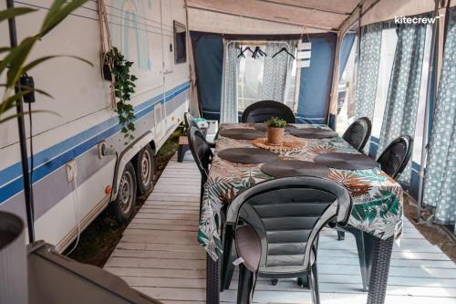a table and chairs in an rv dining room at Przyczepy Kempingowe CHAŁUPY 6, KITE CREW in Chałupy