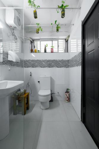 a white bathroom with a toilet and a sink at Sixteen By Sixteen in Lagos