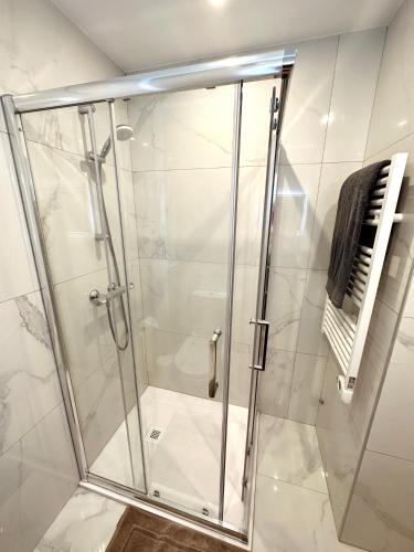 une douche avec une porte vitrée dans une salle de bain dans l'établissement Appartement proche de Cannes avec parking privé, au Cannet