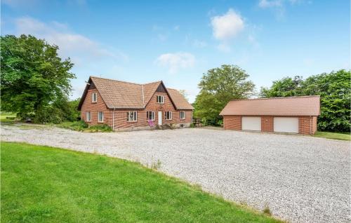 a house with a gravel driveway and a garage at Four-Bedroom Holiday Home In Grenaa in Brøndstrup