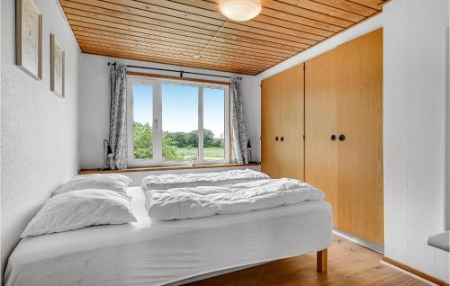 a bedroom with a large bed and a window at Four-Bedroom Holiday Home In Grenaa in Brøndstrup