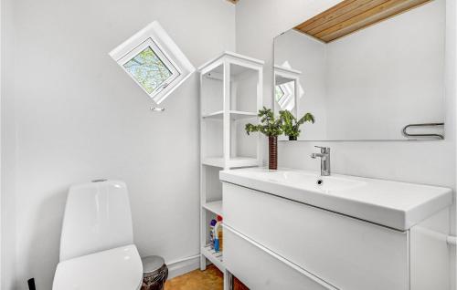 a bathroom with a sink and a toilet and a window at Four-Bedroom Holiday Home In Grenaa in Brøndstrup