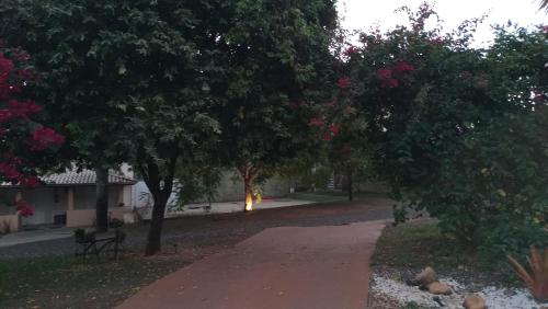 a park with trees and a path with a bench at Biomas Hotel in Brotas